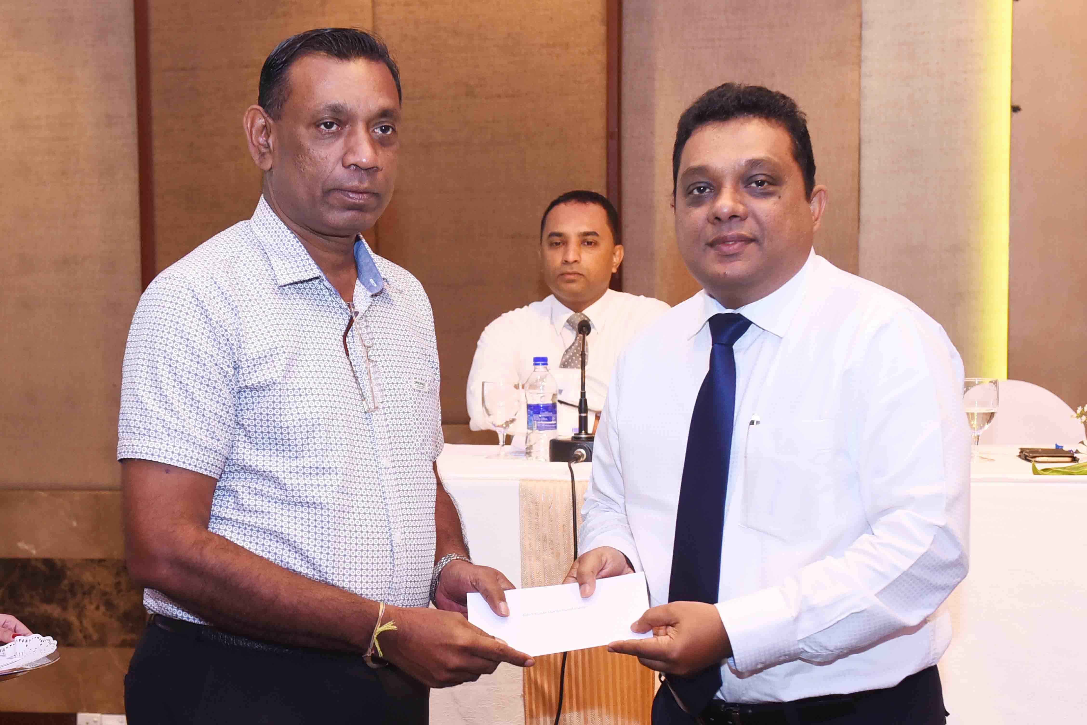 SriLankan Airlines Sales Manager Sri Lanka and Maldives Jayantha Abeysinghe handing over the Pilgrim Promoter Loyalty Card to President of the Buddhist Tour Operators Association  I P S Gunasekara.