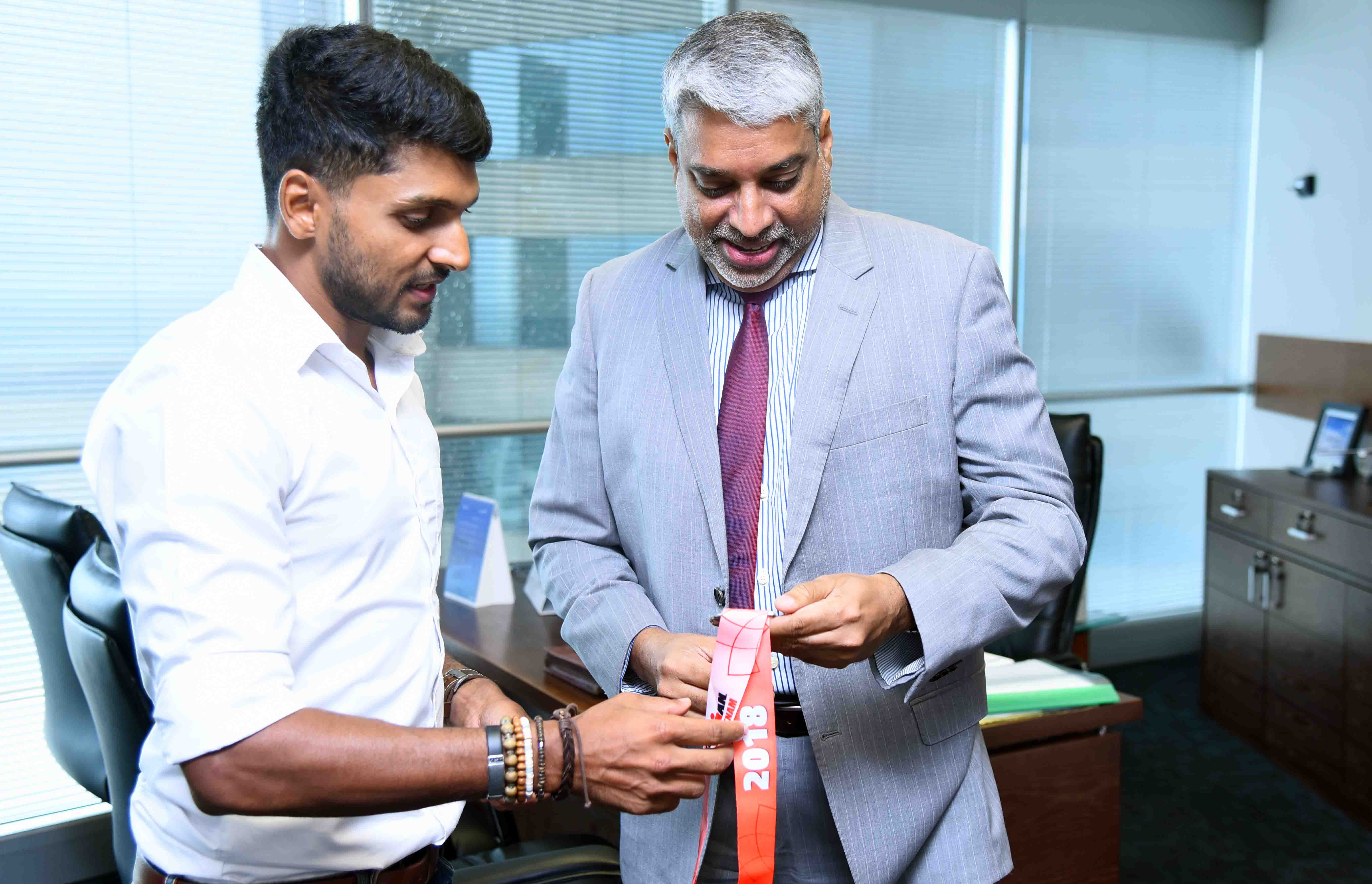 Mithun presenting winning medals to CEO Capt. Suren Ratwatte at his office
